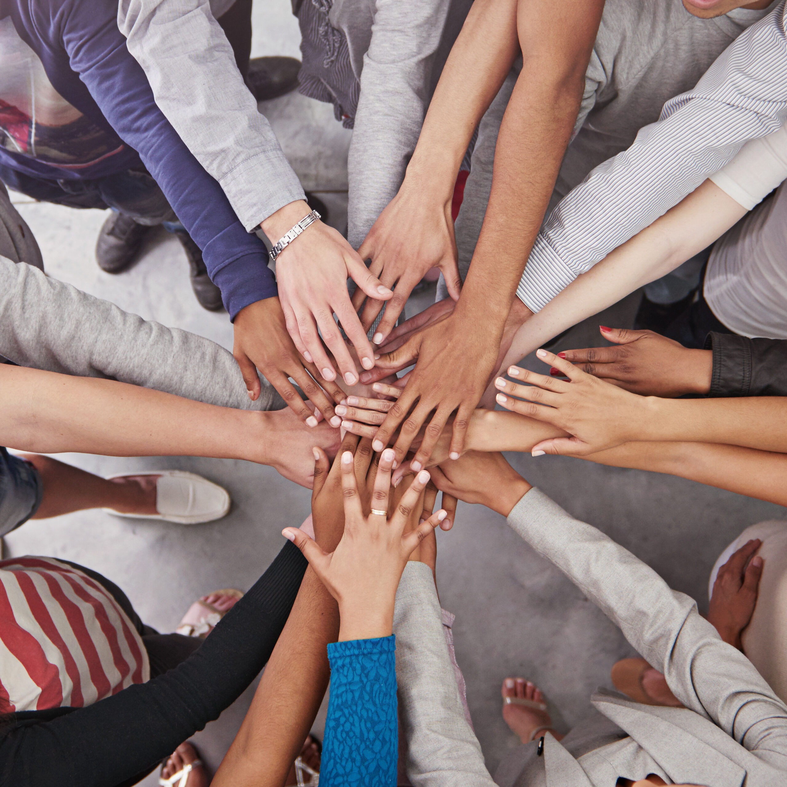 cropped shot of a business team standing in a circle with their hands stacked.