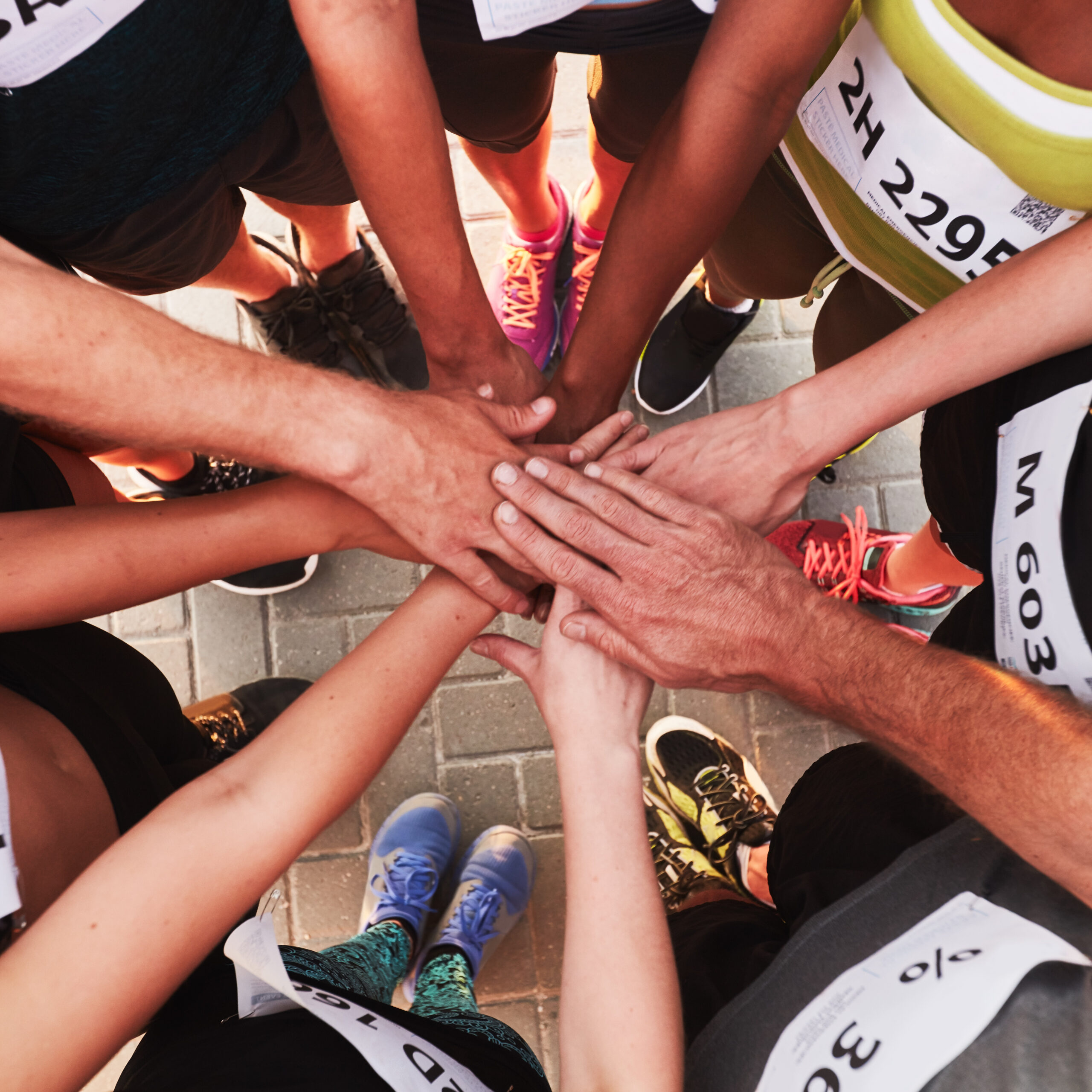 hands of running team stacked on top of each other