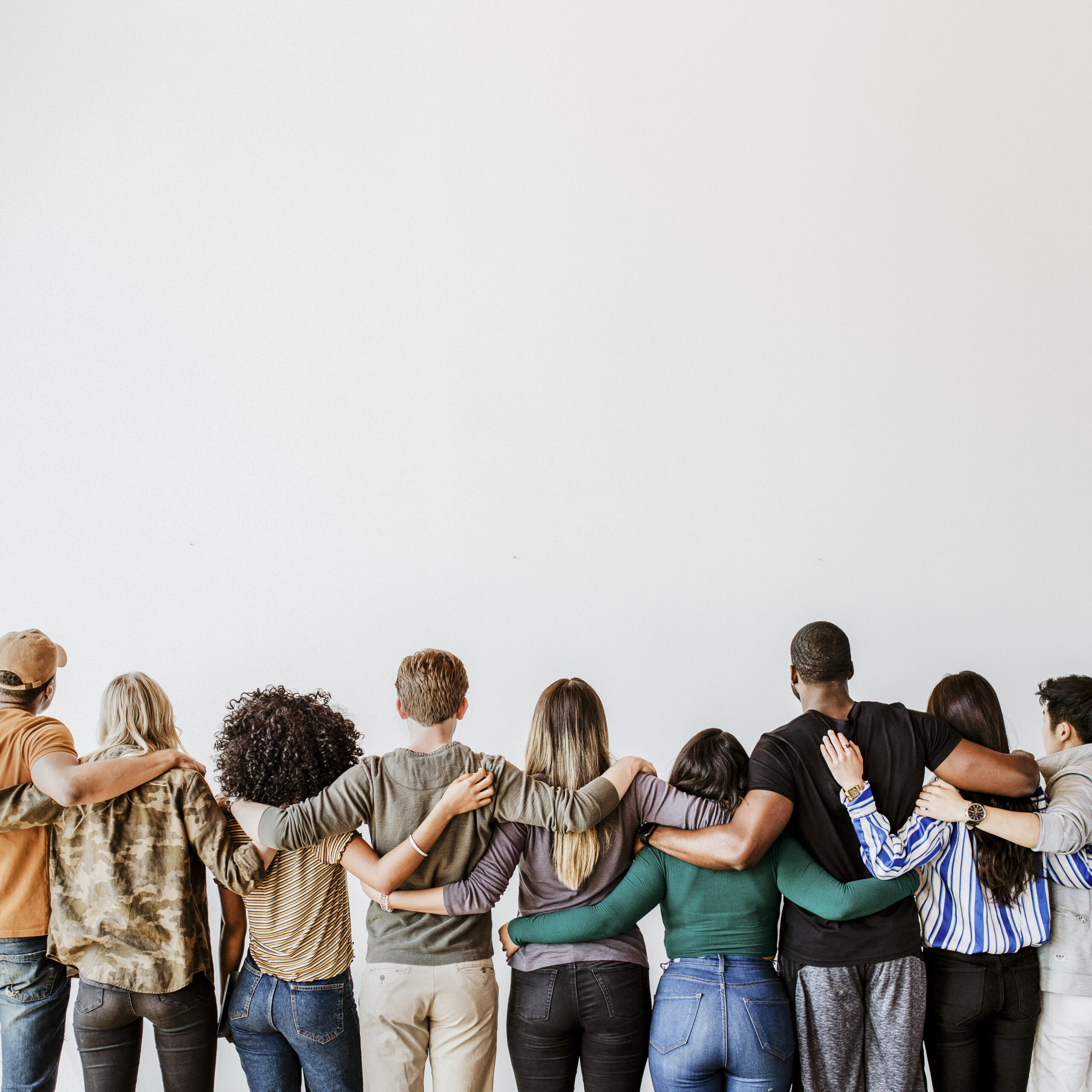 rearview of diverse people hugging each other